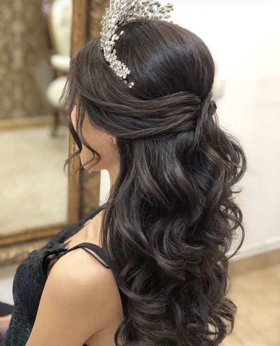 A woman with a tiara in her hair, showcasing a Quinceanera hairstyle