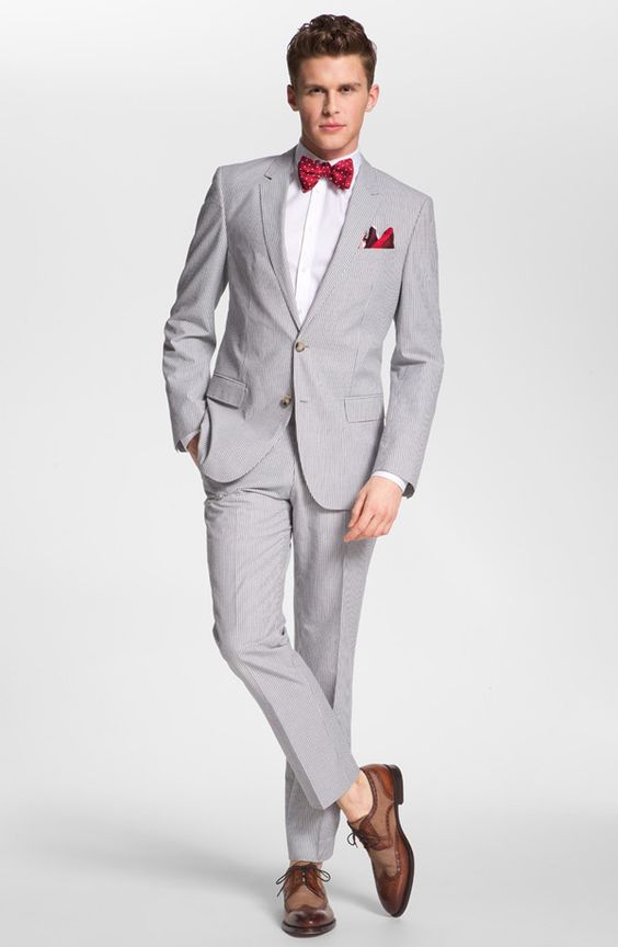 A gentleman in a grey suit with a red bow tie