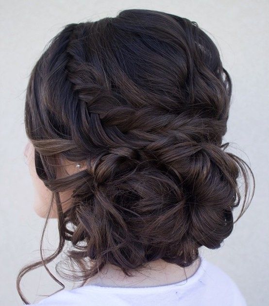 A woman with a messy updo and a white t-shirt wearing a fall Quinceanera hairstyle comb.