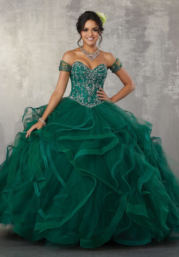 A woman in a gown Quinceañera dress, posing for a picture in a green dress
