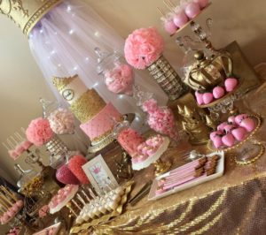 A Quinceanera candy table with pink and gold decorations, provided by Bulk Candy Store
