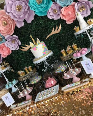 Floral design with a table topped with lots of cakes and desserts for a Quinceanera celebration