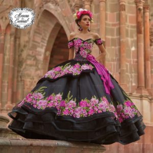 Quinceanera: A woman in a black and pink gown standing in front of a building