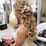 A Quinceanera woman with a flower in her hair showcasing a beautiful hairstyle for long hair