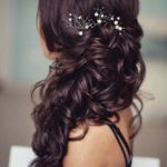 A woman with a hair comb in her hair, showcasing a formal hairstyle for long hair to the side, perfect for a Quinceanera celebration