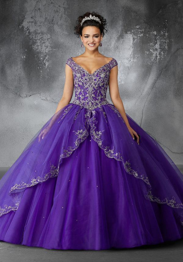 Quinceañera dresses, a woman in a dark purple ball gown posing for a picture