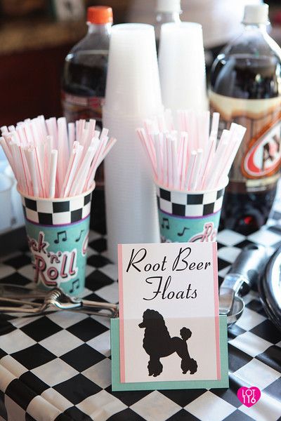 A Quinceanera themed image featuring sock hop food decorations from the 1950s. The image shows a black and white checkered table topped with pink paper straws.