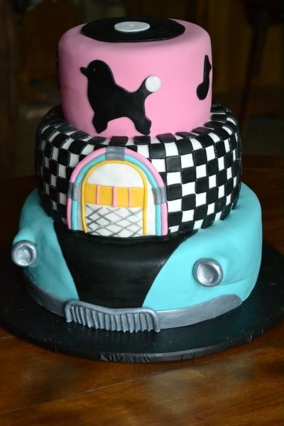 A Quinceanera themed three tiered cake with a car and a dog on top