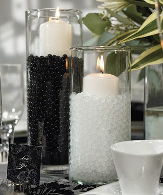 A close up of a black Quinceanera party centerpiece table setting with candles.