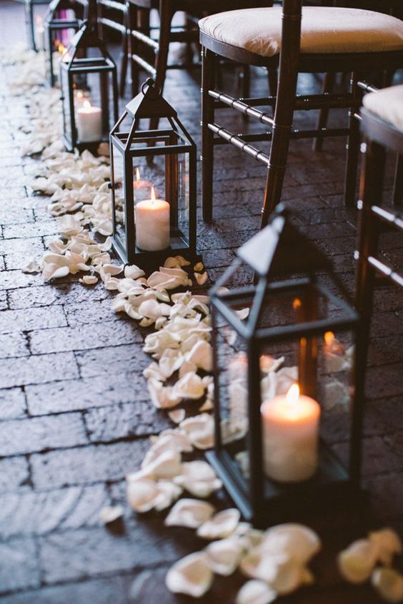 Lanterns at a Quinceanera, a row of chairs with candles and petals on the ground
