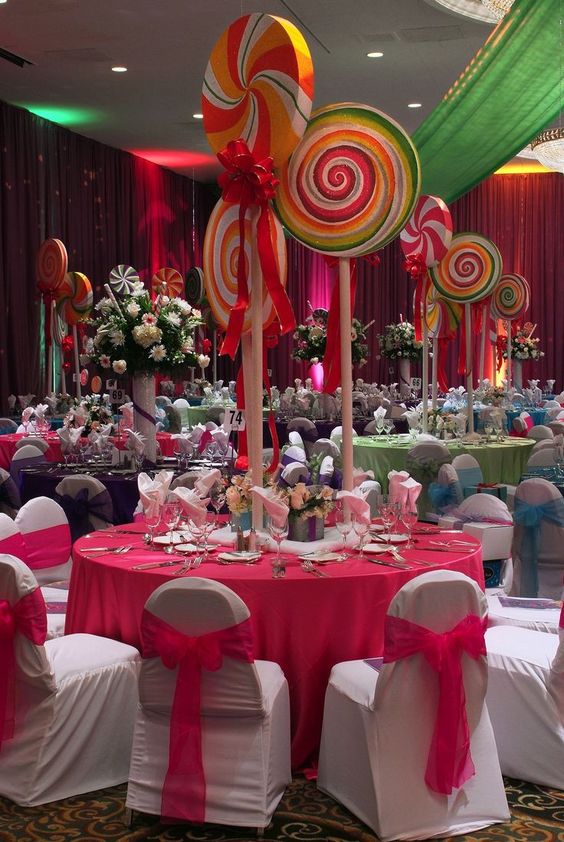 A candyland quinceanera theme party with a table covered in pink and green decorations.
