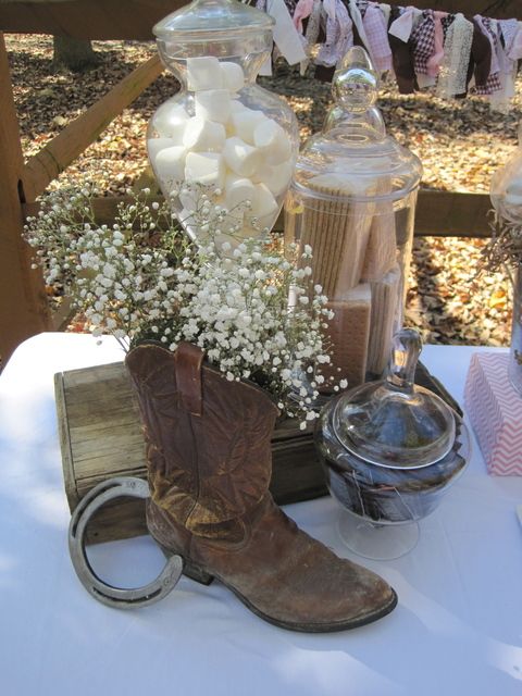 Quinceanera vaquera decoracion: A table with a cowboy boot and a vase of flowers