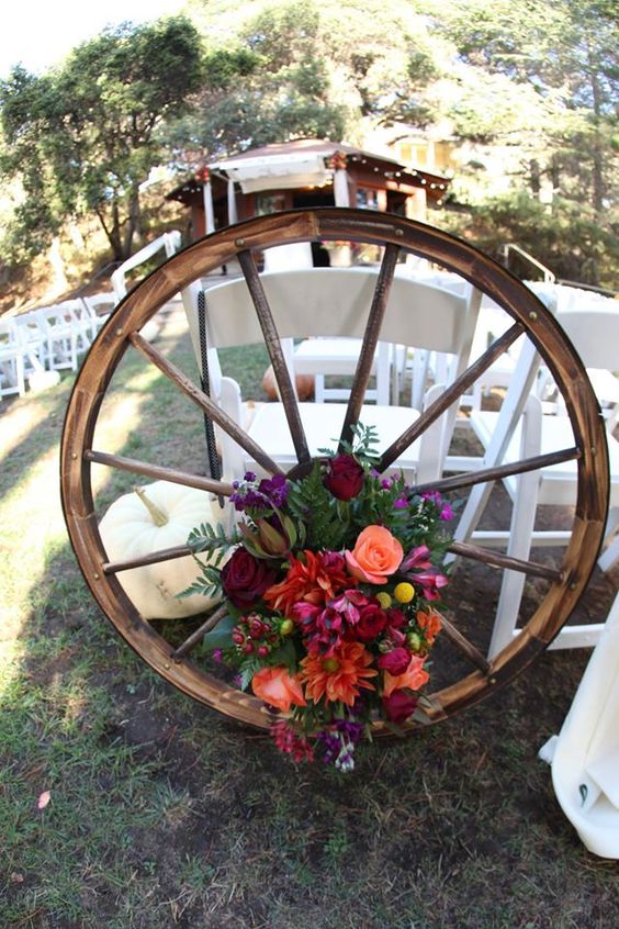 Quinceanera decorations: A wagon wheel with a bunch of flowers on top of it