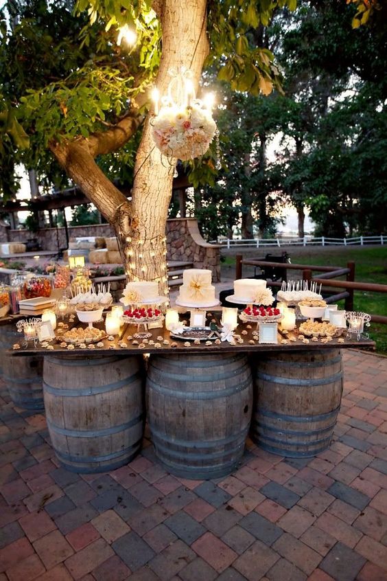 Quinceanera celebration with a DIY party bar filled with food, showcased on a table near a tree.
