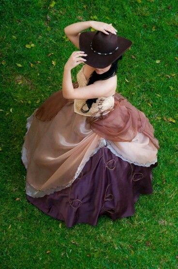 Quinceañera dress creation, a woman in a dress and a hat sitting on the grass, vestidos de 15 años estilo vaquero