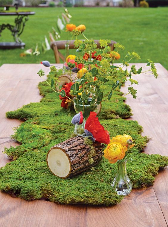 Quinceanera table: a wooden table topped with moss and flowers