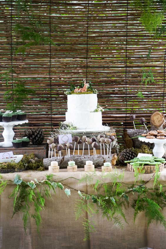 Quinceanera forest party ideas - A table with a cake and cupcakes on it