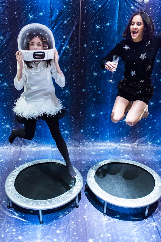 Two girls in space suits jumping on a trampoline in a Quinceañera themed space photobooth party