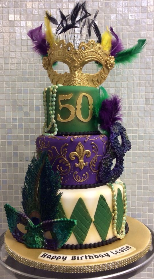 Quinceanera themed cake: King cake, a purple and green cake with a mask on top