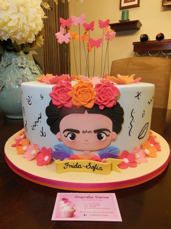 A Quinceanera party with a cake featuring Frida Kahlo on top of it