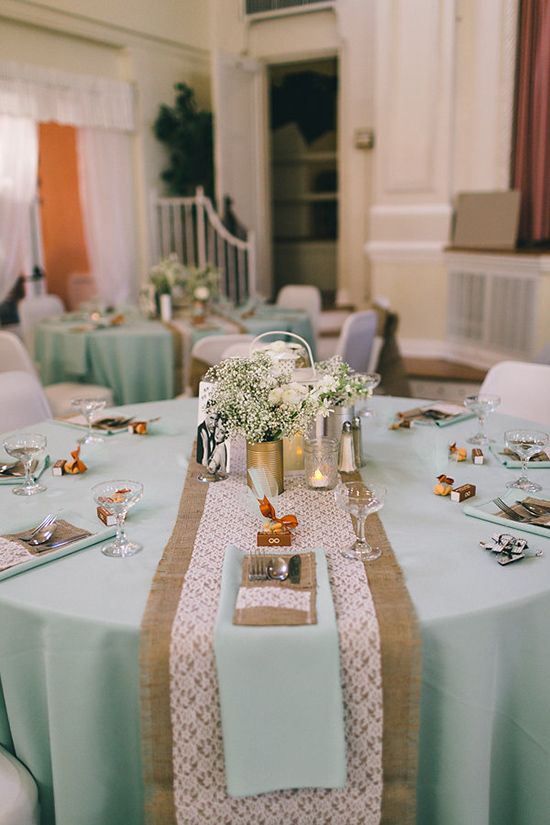 Quinceanera decoration with mint accents. A table is set with place settings and tableware.