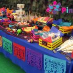 A quinceañera celebration with a charro theme. The image features beautiful Quinceañera dresses and a table adorned with colorful decorations.