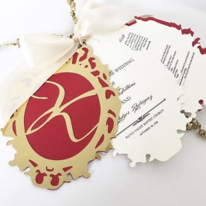 A red and gold Christmas ornament with a white ribbon, perfect for a Quinceanera celebration