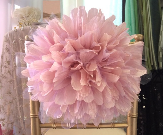 A Quinceanera themed pom pom Chair, featuring a chair with a pink flower on top of it.