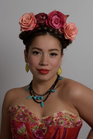 A woman wearing a Quinceanera dress with a floral headpiece.