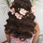 A woman with long brown hair wearing a flower crown on her head, for a Quinceanera