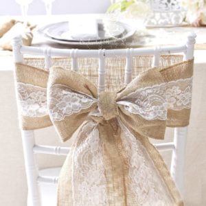 Rustic Quinceanera chair sashes - A chair with a bow tied to it