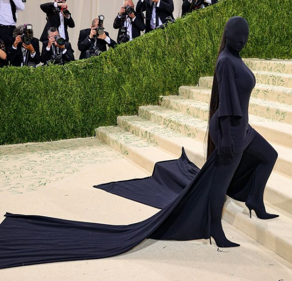 Kim Kardashian at the 2021 Met Gala wearing a black dress and a black cape, in the theme of Quinceanera.