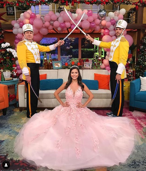 A woman in a pink Quinceanera gown standing next to a man in a yellow jacket