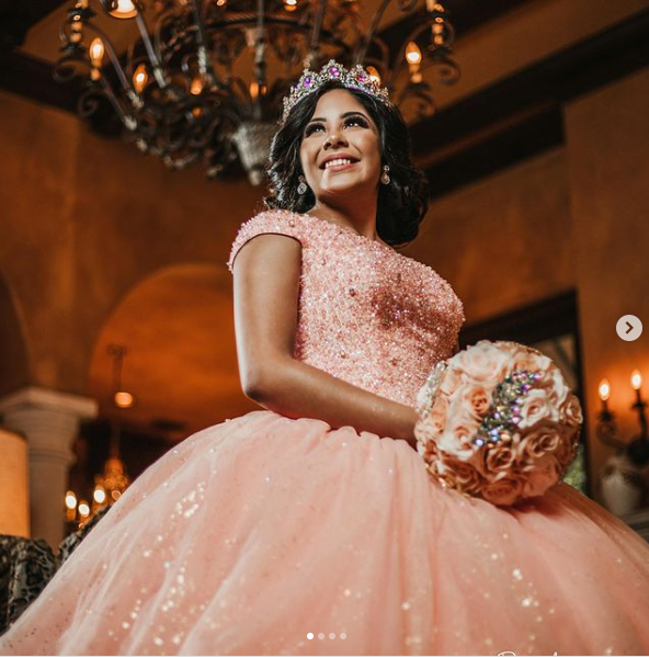 A woman in a Quinceanera gown holding a bouquet