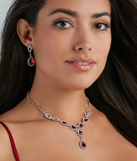 A woman in a red dress wearing a necklace and earrings at a Quinceanera
