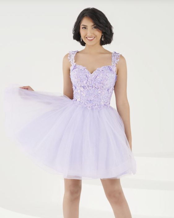 A woman in a purple Quinceanera dress posing for a picture showcasing cocktail dress
