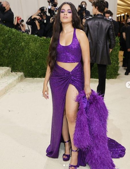 A woman in a purple dress posing for the camera at a Quinceanera event with Shawn Mendes