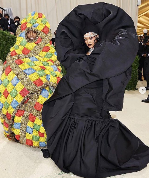 A Quinceanera couple standing together in elaborate costumes at the 2021 Met Gala.