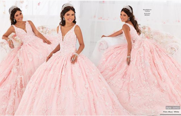 A woman posing for a picture in a pink Quinceanera gown.