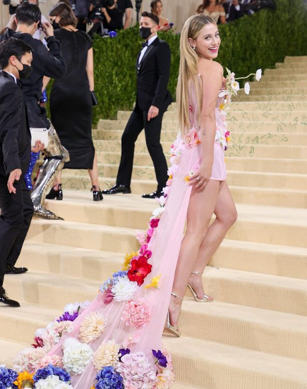 Lili Reinhart, a woman in a pink dress is walking up the stairs at a Quinceanera celebration with Ali Gul Pir