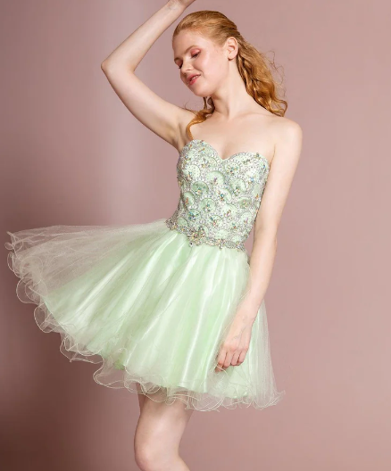A Quinceanera woman posing for a picture in a short green cocktail dress