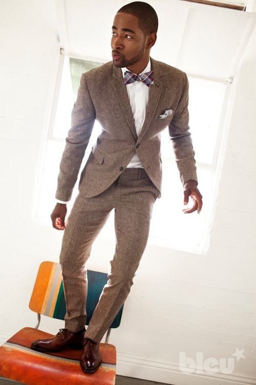A man in a suit standing on a chair wearing a terno suitable for Quinceanera with dark skin