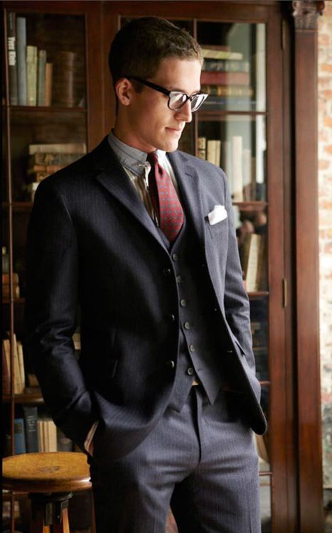 A man in a suit standing in front of a bookcase at a Quinceanera celebration