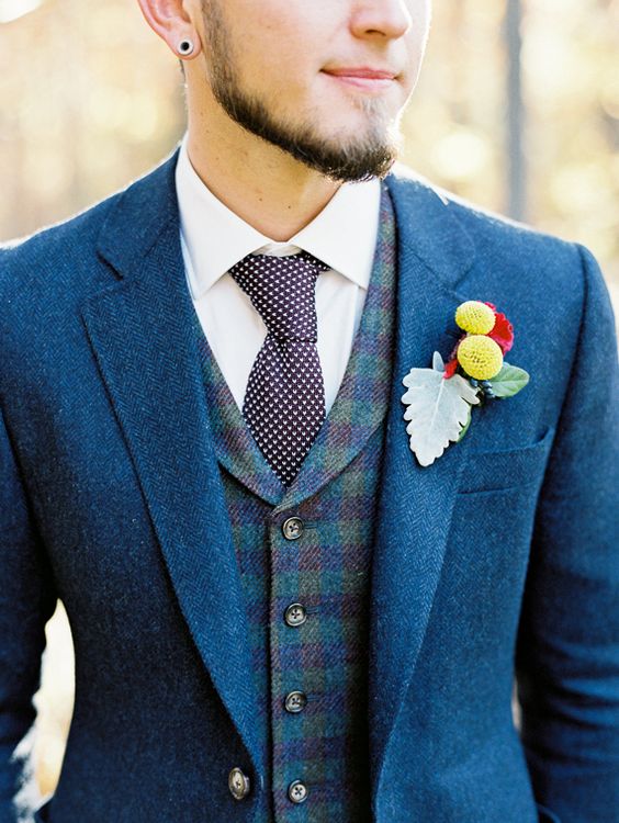 A man wearing a rustic blue suit and tie for a Quinceanera, with a flower in his lapel