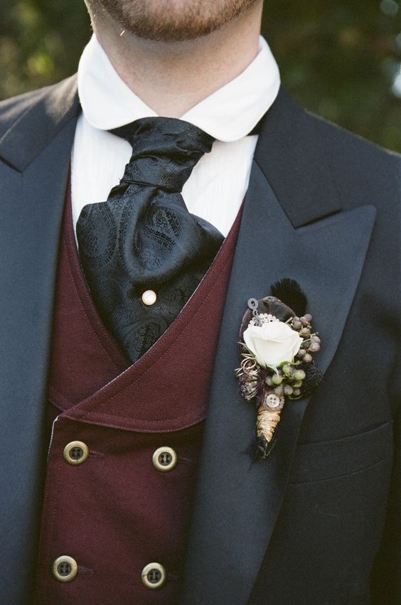 A close up of a person wearing a suit and tie with a Steampunk boutonniere at a Quinceanera event.