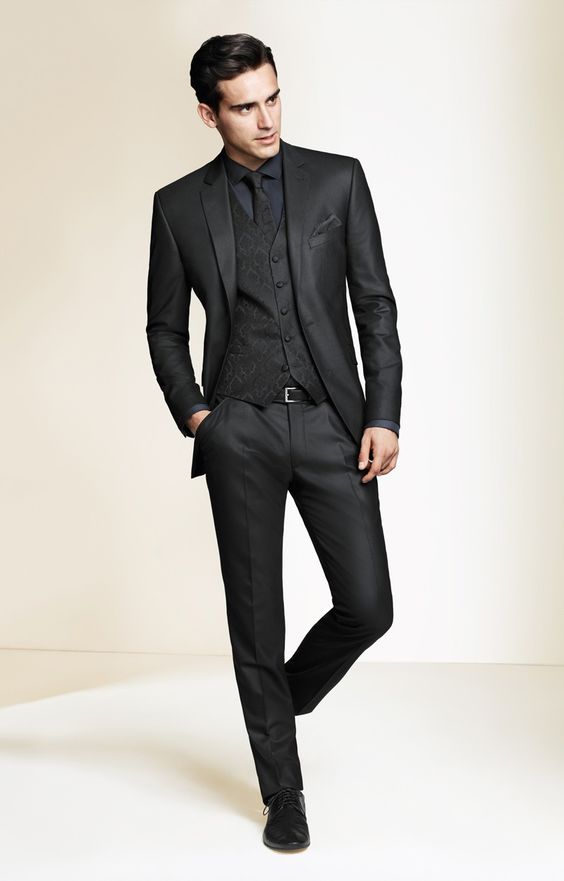 A man wearing a black tuxedo suit and tie, perfect for a Quinceanera celebration
