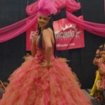 A Quinceanera dancer Barbie and a woman in a pink dress standing on a stage