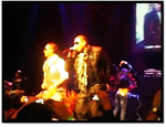 Two men standing on top of a stage at a Quinceanera rock concert.