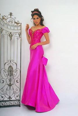 Quinceanera gown, a woman in a pink dress standing in front of a gate