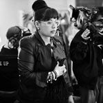 Black-and-white monochrome photography of a woman holding a camera at a Quinceanera event